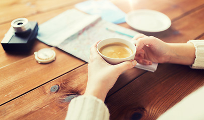 Image showing close up of hands with coffee cup and travel stuff