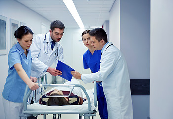 Image showing medics and patient on hospital gurney at emergency