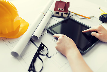 Image showing close up of hand with blueprint and tablet pc