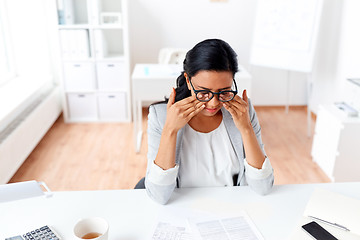 Image showing businesswoman rubbing tired eyes at office