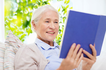 Image showing happy smiling senior woman reading book at home