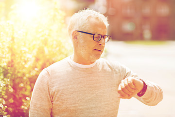 Image showing senior man checking time on his wristwatch