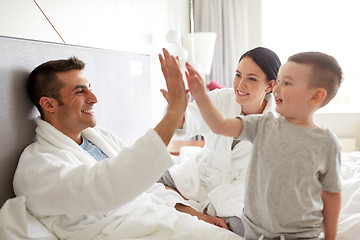 Image showing happy family in bed at home or hotel room