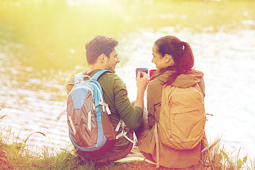 Image showing happy couple with cups drinking in nature