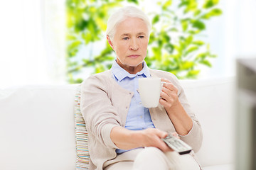 Image showing senior woman watching tv and drinking tea at home