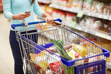 Image showing woman with smartphone buying food at supermarket