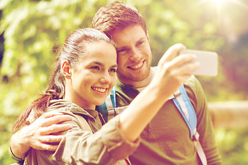 Image showing couple with backpacks taking selfie by smartphone