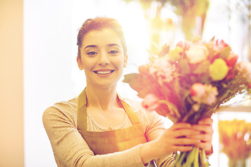 Image showing smiling florist woman making bunch at flower shop