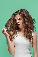 Image showing Frustrated young woman having a bad hair on blue