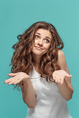 Image showing Frustrated young woman posing on blue