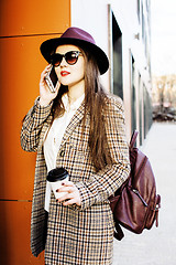 Image showing young pretty hipster girl student with coffee cup posing adorable smiling, lifestyle people concept outdoor