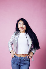 Image showing young pretty smiling asian korean girl wearing modern fashion clothers on pink background, lifestyle people concept