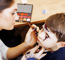 Image showing little cute child making facepaint on birthday party, zombie Apo