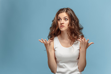 Image showing Portrait of an angry woman looking away on a blue background