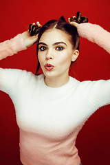 Image showing young pretty emitonal posing teenage girl on bright red background, happy smiling lifestyle people concept closeup