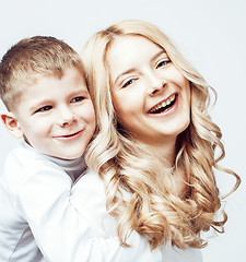 Image showing young modern blond mother with cute son together happy smiling family posing cheerful on white background, lifestyle people concept, sister and brother friends 