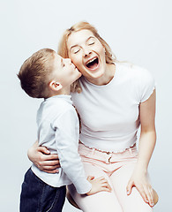 Image showing young modern blond mother with cute son together happy smiling family posing cheerful on white background, lifestyle people concept, sister and brother friends 