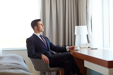 Image showing businessman drinking coffee at hotel room