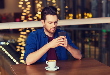 Image showing man with smartphone and coffee at restaurant