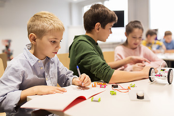 Image showing happy children building robots at robotics school