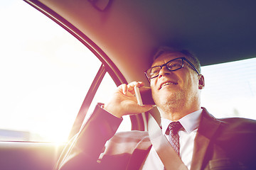 Image showing senior businessman calling on smartphone in car