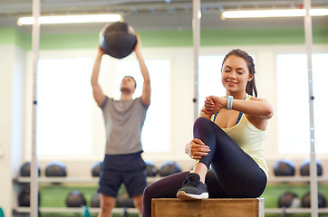 Image showing man and woman with ball and fitness tracker in gym
