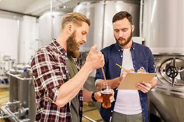 Image showing men with pipette testing craft beer at brewery