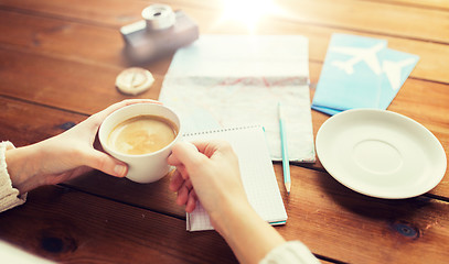 Image showing close up of hands with coffee cup and travel stuff