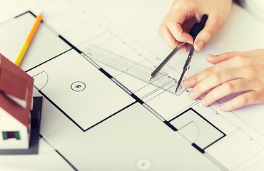 Image showing close up of hands with compass measuring blueprint