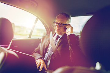 Image showing senior businessman calling on smartphone in car