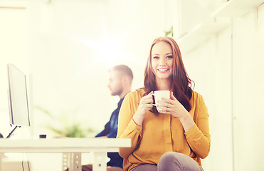 Image showing happy woman drinking coffee or tea at office