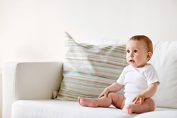 Image showing happy baby boy or girl sitting on sofa at home