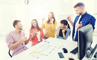 Image showing happy creative team celebrating success at office