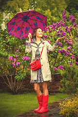 Image showing Beautiful woman with an umbrella in red rubber boots