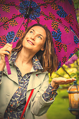 Image showing Smiling woman with umbrella in the rain