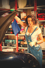 Image showing beautiful woman in a jeans jumpsuit of a car mechanic opened the