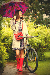 Image showing beautiful middle aged woman with umbrella and bicycle