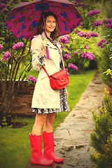 Image showing happy middle-aged woman in rubber boots with umbrella