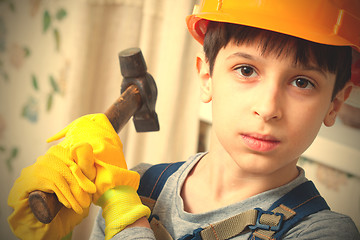 Image showing boy in a protective helmet and with a hammer 