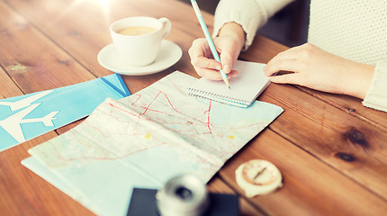 Image showing close up of traveler hands with notepad and pencil