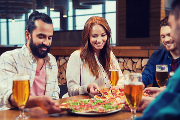 Image showing friends eating pizza with beer at restaurant