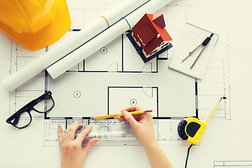 Image showing close up of hands with ruler measuring blueprint