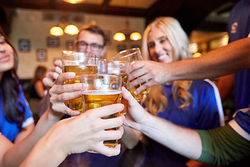 Image showing football fans clinking beer glasses at sport bar