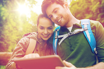 Image showing happy couple with backpacks and tablet pc outdoors