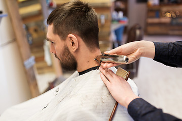 Image showing man and barber hands with trimmer cutting hair