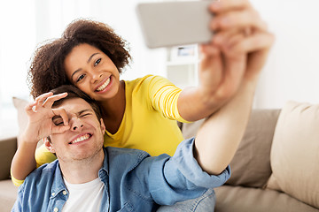 Image showing happy couple with smartphone taking selfie at home