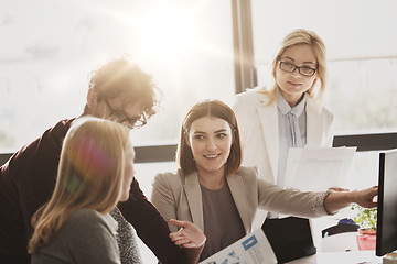 Image showing happy creative team with computer in office