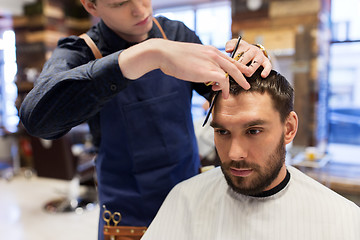 Image showing man and barber cutting hair at barbershop