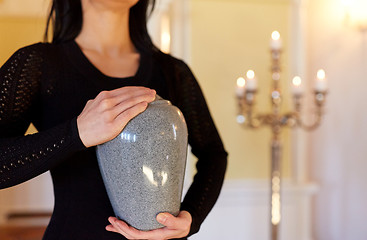 Image showing close up of woman with cremation urn in church