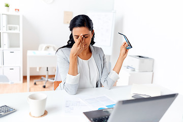 Image showing businesswoman rubbing tired eyes at office